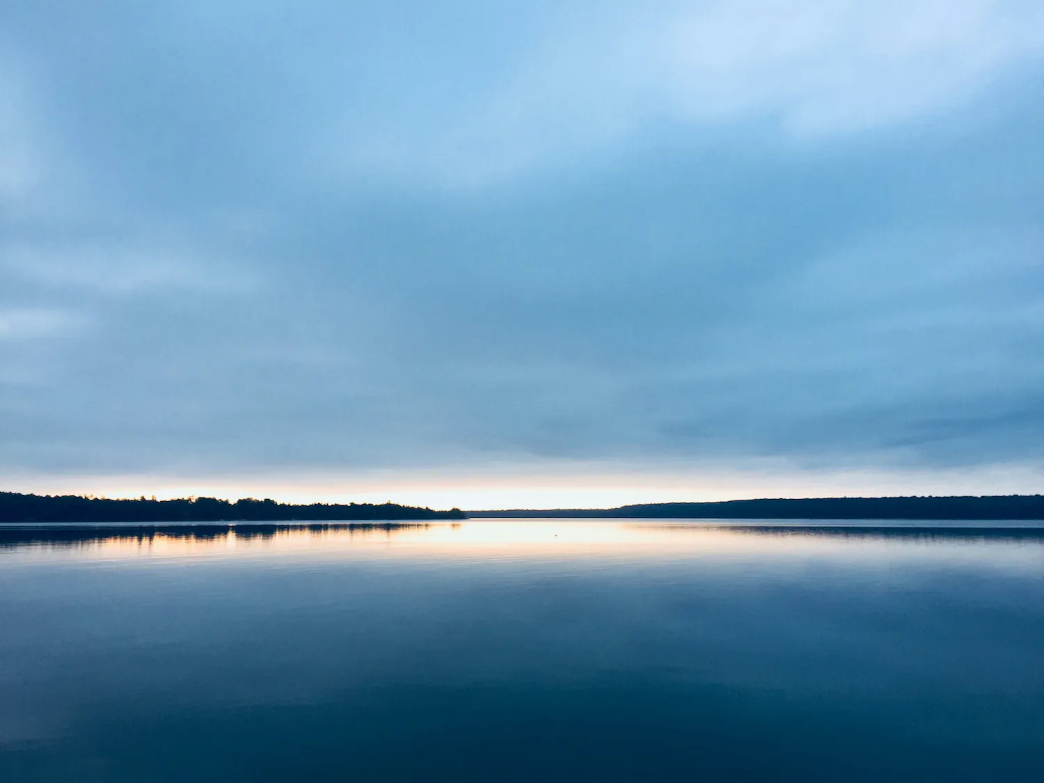 Calm water representing how diversification smooths out volatility in an ETF basket
